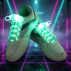 White sneakers with green LED shoelaces on a dark surface