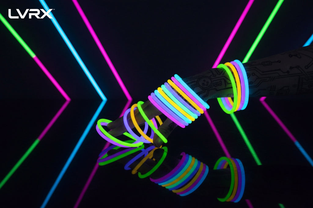 Glow bracelets in various colors on a hand against a black background