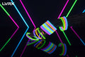 Glow bracelets in various colors on a hand against a black background