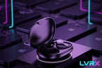 Black wireless earbuds in an open case on a blurred background of electronic devices.