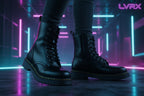 Black leather boots with yellow stitching on a stone surface