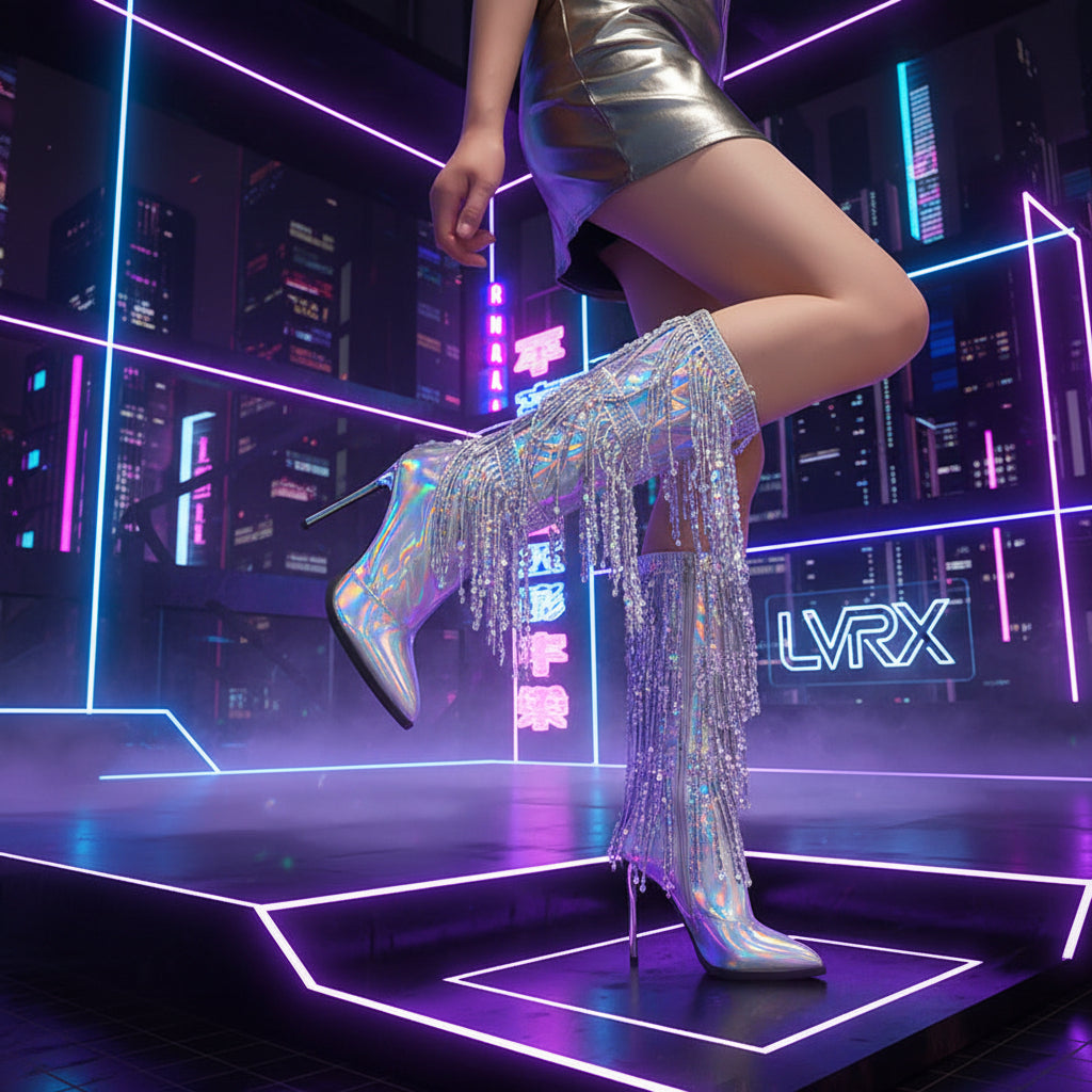 Shiny silver high-heeled boots with fringe details worn by a person against a dark background.