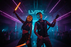 Two people wearing neon LED masks with a blurred background