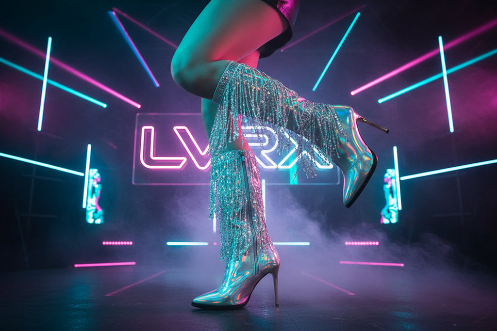 Shiny high-heeled boots with fringe details worn by a person 