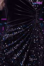 Close-up of LVRX sequin dress showing thousands of sequins catching electric blue and neon pink light